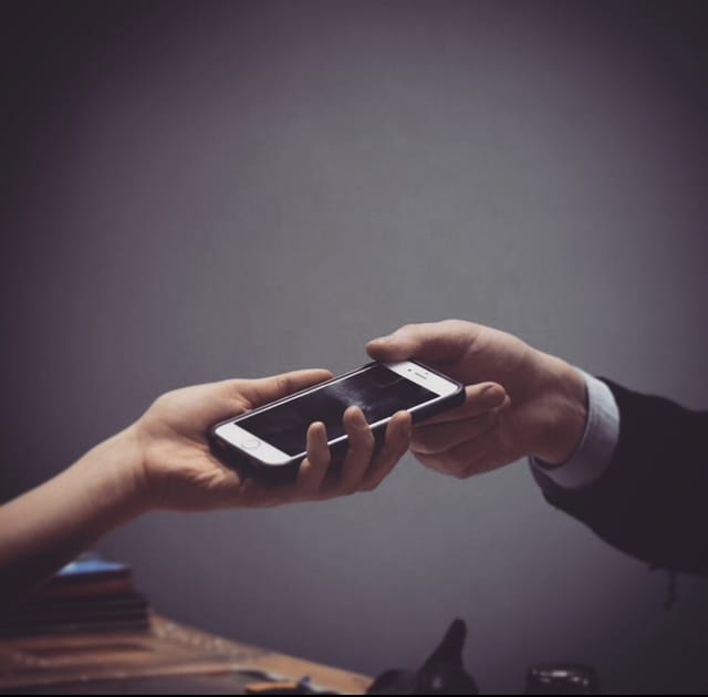 a phone being handed to a technician
